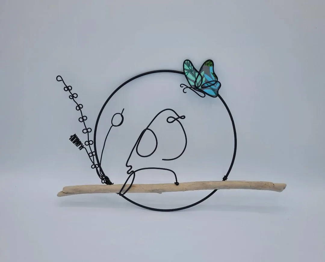 Oiseau perché en fil d'aluminium noir dans un cercle sur bois flotté, avec papillon en tissu turquoise, décoration nature artisanale — Florifer